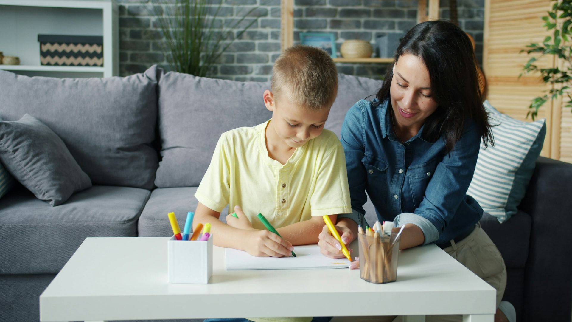 A woman works alongside a boy at a table
